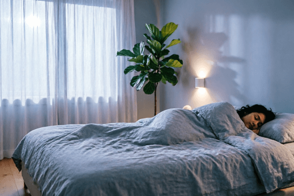 Peaceful bedroom with comfortable bedding representing restful sleep after using the best anti-snoring aids.